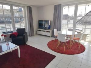 a living room with a table and chairs and a tv at Apartmentvermittlung Mehr als Meer - Objekt 18 in Niendorf