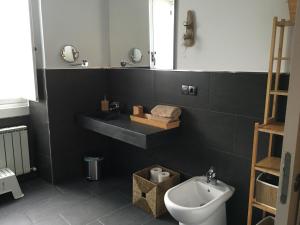 a bathroom with a sink and a toilet and a mirror at Apartamentos cercanos playa 1 in Puentedeume