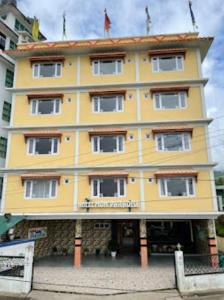 a yellow building with a sign on it at Hotel Mon Paradise, Tawang in Tawang