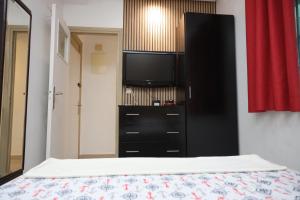 a bedroom with a black dresser with a flat screen tv at Agdal 1 in Rabat