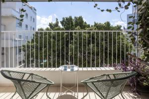 un patio con 2 sillas y una mesa en el balcón en Appartements BnBIsrael - Hovevei Tsiyon Jasmin, en Tel Aviv