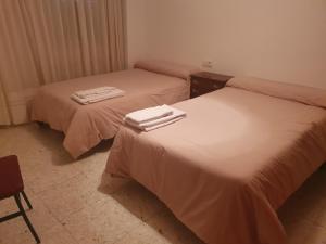 two beds with towels on top of them in a room at Casa Ventana Cazorla in Cazorla