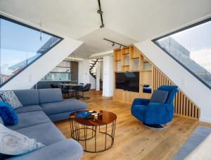 uma sala de estar com um sofá e cadeiras e uma televisão em Nook Zehn Apartments & Loft by Irundo em Viena