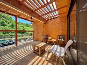 a wooden patio with a table and chairs on it at SUMITSUGU HOUSE West in Kumamoto