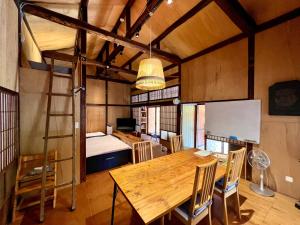熊本市にあるSUMITSUGU HOUSE Westの木製テーブルと二段ベッドが備わる客室です。