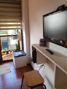 een kamer met een bureau en een grote televisie aan de muur bij Departamento cerca de la playa in Mar del Plata