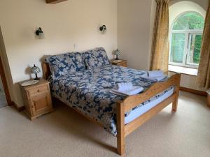 sypialnia z łóżkiem z niebieską kołdrą i oknem w obiekcie Copley House w mieście Richmond