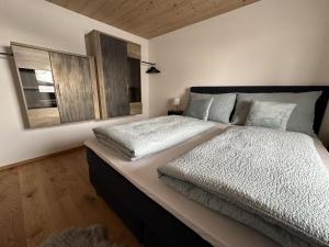 um quarto com uma cama grande e lençóis brancos em Apartment Troger em Fieberbrunn