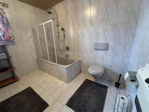 een badkamer met een bad en een toilet bij Apartment Troger in Fieberbrunn +17 foto's