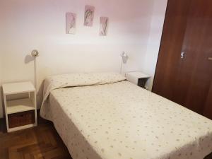 een slaapkamer met een bed en twee foto's aan de muur bij Departamento cerca de la playa in Mar del Plata
