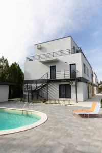 une maison avec une piscine à côté d'un bâtiment dans l'établissement Studio 8 I One Bedroom Apartment I Airport I Therme, à Otopeni