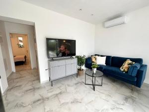 un soggiorno con un divano blu e una TV a schermo piatto di Olive View Apartment Brela - pet friendly a Brela