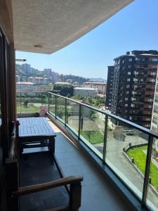 een balkon met een bank en uitzicht op de stad bij BABİLON REZİDANS in Rize