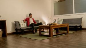 塔那那利佛的住宿－Grand Appart'Antaninarenina，坐在客厅沙发上的男人