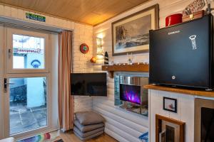 a living room with a flat screen tv and a fireplace at Finest Retreats - Treknow Summerhut in Tintagel