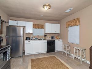 eine Küche mit weißen Schränken und einem Kühlschrank aus Edelstahl in der Unterkunft Charming 3BR Home w/ Private Yard 