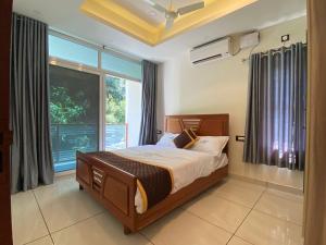 a bedroom with a bed and a large window at Grand Residency & Resort in Varkala