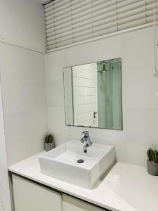 a bathroom with a white sink and a mirror at Sibaya Umhlanga Apartments in Umhlanga