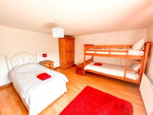 a bedroom with two bunk beds and a red rug at Brookside in Langthwaite