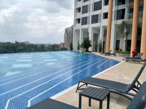 a large swimming pool with chairs next to a building at Hann's Lodge in Putrajaya