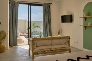 um quarto com um sofá e uma porta de vidro deslizante em Kawga Hôtel em Ngaring