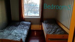 two beds in a room with a window at The grey house in Liland