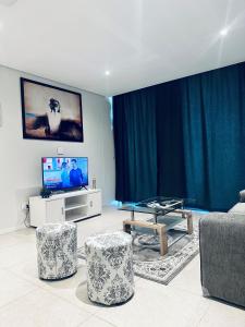 a living room with a tv and two chairs and a table at Sibaya Umhlanga Apartments in Umhlanga