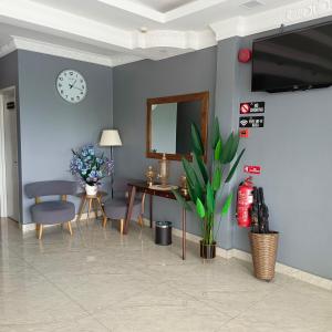 ein Wohnzimmer mit einer blauen Wand mit einem Spiegel und einem Tisch in der Unterkunft Royale City Hotel - 10 min from KLIA KLIA 2 Airport in Sepang