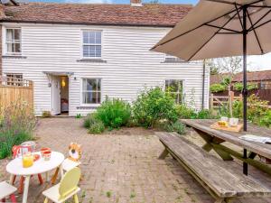 a patio with a picnic table and an umbrella at 2 Bed in Horsted Keynes 60405 in Horsted Keynes