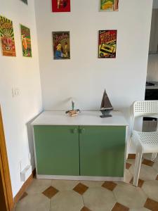 un armadietto verde in una stanza con foto sul muro di Noto…sul mare! a Noto Marina