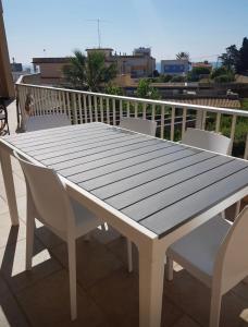 un tavolo e sedie in legno bianco sul balcone di Noto…sul mare! a Noto Marina