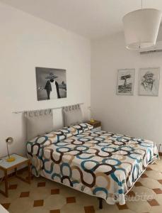 una camera da letto con un letto con un piumone colorato di Noto…sul mare! a Noto Marina