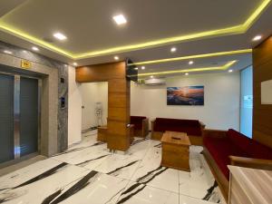 vestíbulo con sofá rojo y mesa en Grand Residency & Resort en Varkala
