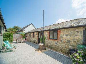 a stone house with a patio with a bench at 2 bed in Godshill IC085 in Godshill