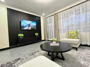 Naka Tranquil Suite with Ample Secure Parking في ناكورو: غرفة معيشة مع أريكة وطاولة