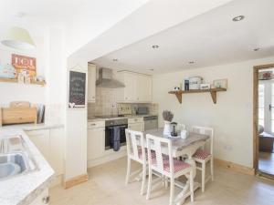 cocina con armarios blancos, mesa y sillas en 2 bed in Winterton on Sea KT096, en Winterton-on-Sea