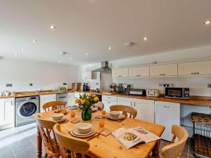una cucina con tavolo in legno e sedie e una cucina con di 2 Bed in Osmotherley 64413 a Osmotherley