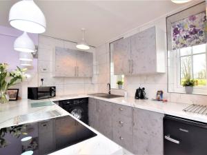 een keuken met witte kasten en een vaatwasser bij 1 bed in Beccles 65080 in Beccles