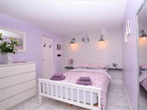 een slaapkamer met een wit bed en paarse muren bij 1 bed in Beccles 65080 in Beccles