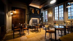 a restaurant with tables and chairs and a fireplace at Hotel De Guise Nancy Vieille Ville in Nancy