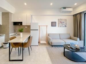 a kitchen and living room with a couch and a table at Prince Huan Yu Center Hotel & Residence太子寰宇中心酒店公寓 in Phnom Penh