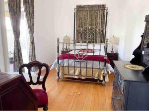 1 dormitorio con 1 cama y suelo de madera en The Old Station Masters House, en Maryborough