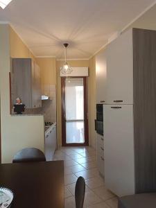 a kitchen with a refrigerator and a door to a room at Cielle's House - IUN R5309 in Sestu