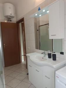 a white bathroom with a sink and a mirror at Cielle's House - IUN R5309 in Sestu