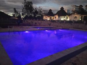 a swimming pool with blue lights in the night at TURACO INTERCOUNTY RESORT in Maragoli