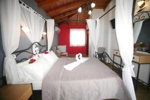ein Schlafzimmer mit einem Bett mit zwei Schwänen darauf in der Unterkunft Coralli Rooms & Restaurant in Elafonisos