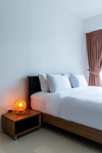 a bedroom with two beds and a table with a lamp at Chic Condominium by Redfox Hospitality in Karon Beach