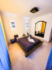 New Marina Hurghada Suite في الغردقة: غرفة نوم بسرير كبير ومرآة كبيرة