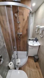 a bathroom with a shower and a toilet and a sink at Apartament SECONDO 