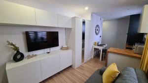 ein Wohnzimmer mit einem TV auf einem weißen Schrank in der Unterkunft Apartament SECONDO 